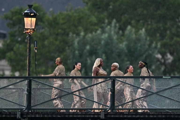Aya Nakamura (C) et des danseurs sur le Pont des arts pour la cérémonie d'ouverture des Jeux olympiques à Paris le 26 juillet 2024