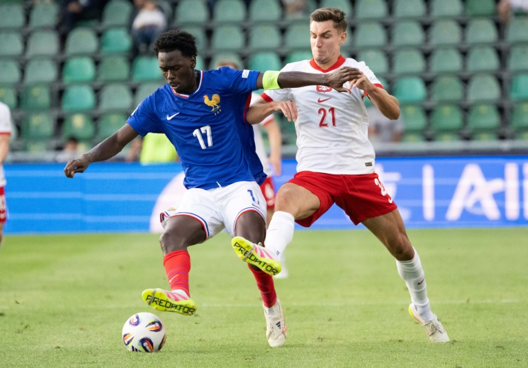 Le Français Soungoutou Magassa (g) et le Polonais Tomasz Pienko lors de la victoire des Bleutes (4-1) à l'Euro espoirs, le 17 juin 2025 à Zilina (Slovaquie)