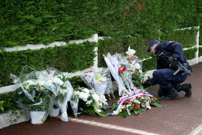 Un policier dépose des fleurs à Magnanville, le 15 juin 2016 après l'assasinat d'un couple de policiers
