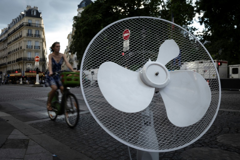 Une cycliste circule près d'un ventilateur abandonné, le 27 juin 2025 à Paris