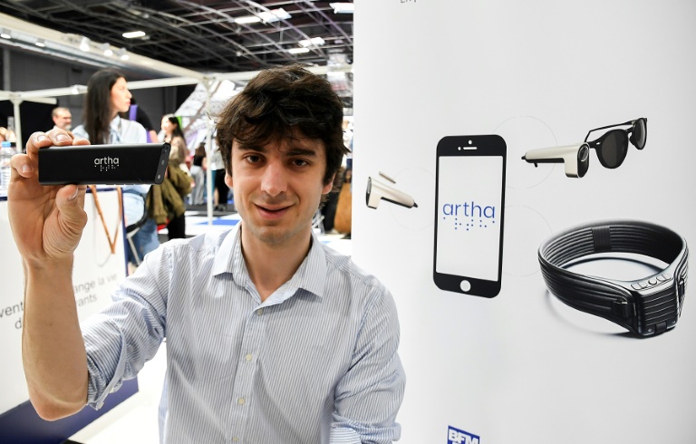 Fondateur français d'Artha France, Rémi Du Chalard présente une mini-caméra qui équipe une paire de lunettes et transmet des données visuelles sous forme de sensations tactiles via une ceinture lombaire à Paris le 10 mai 2024