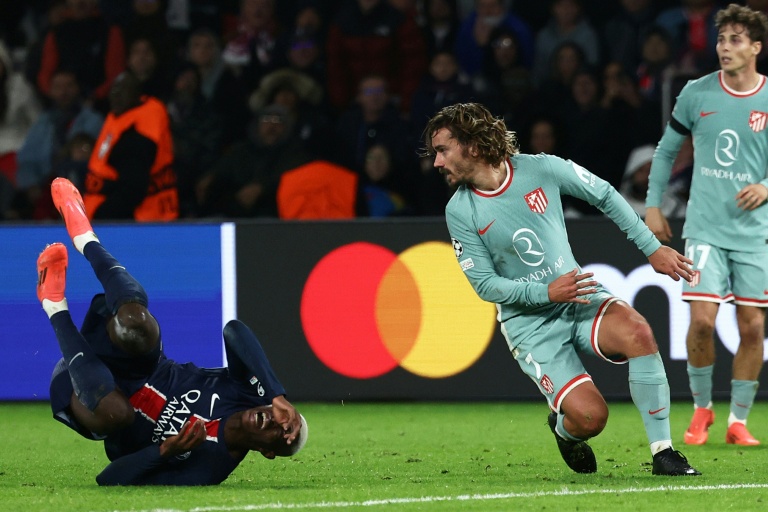 Le défenseur portugais du Paris Saint-Germain Nuno Mendes (g.) au sol à côté de l'attaquant français de l'Atlético Madrid Antoine Griezmann lors d'un match de phase de poule de Ligue des champions, à Paris, le 6 novembre 2024
