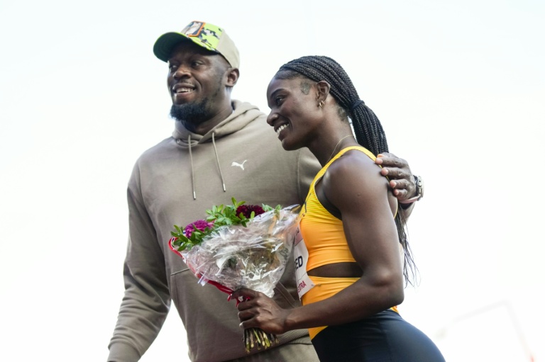 Le coureur jamaïcain retraité Usain Bolt offre des fleurs à la sprinteuse saint-lucienne Julien Alfred (d. ) après qu'elle a remporté l'épreuve du 100 m féminin de l'évènement de la Ligue de diamant d'Oslo au stade Bislett, à Oslo, le 12 juin 2025