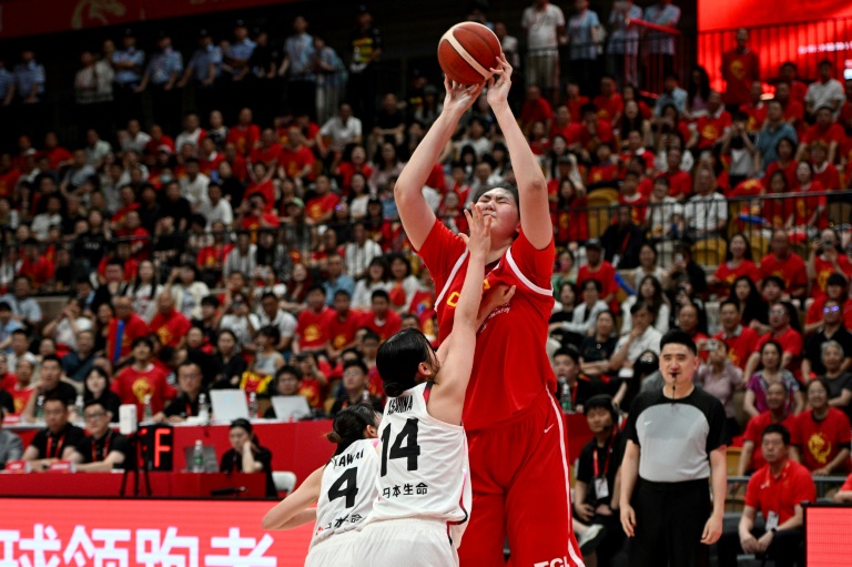 La Chinoise Zhang Ziyu (n°28) tire tandis que les Japonaises Azusa Asahina (n°14) et Mai Kawai (n°4) tentent de bloquer le tir lors d'un match avant la Coupe d'Asie féminine de la FIBA à Xi'an, dans la province centrale chinoise du Shaanxi, le 18 juin 2025