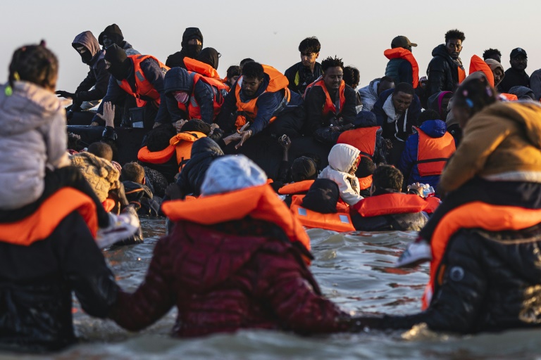 Des migrants montent à bord d'un bateau de passeurs pour traverser la Manche, au large de la plage de Gravelines, le 16 juin 2025 dans le Nord