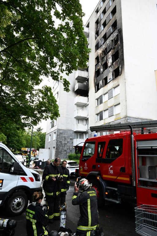 Des pompiers devant la façade noircie d'un immeuble où un incendie a fait quatre morts, le 6 juin 2025 à Reims