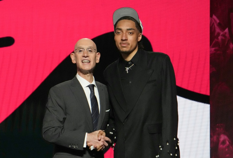 Le Français Noa Essengue (à droite), choisi en 12e position par les Chicago Bulls au premier tour de la draft NBA, avec le commissionnaire de la Ligue de basket nord-américaine Adam Silver le 25 juin 2025 à New York