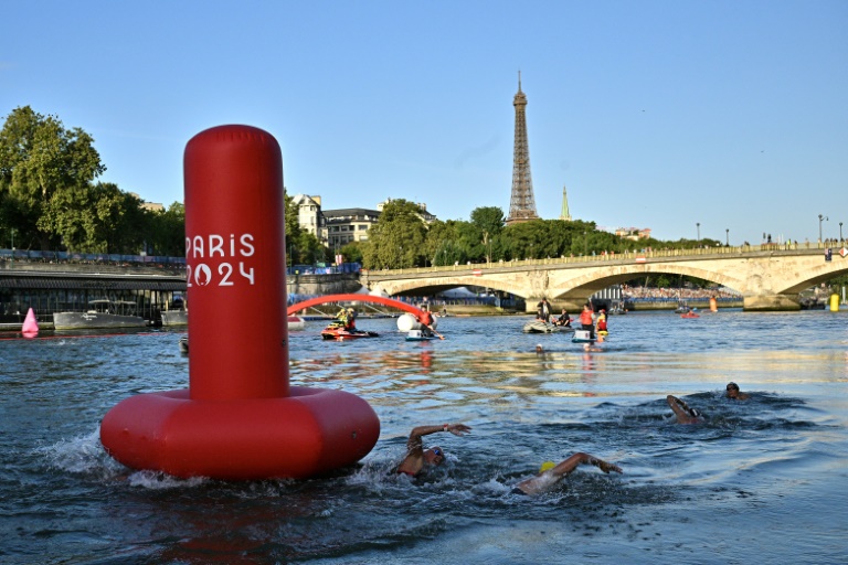 Des athlètes nagent dans la Seine lors de la finale du marathon fémini nde natation de 10 km aux Jeux olympiques de Paris 2024, le 8 août 2024 à Paris 