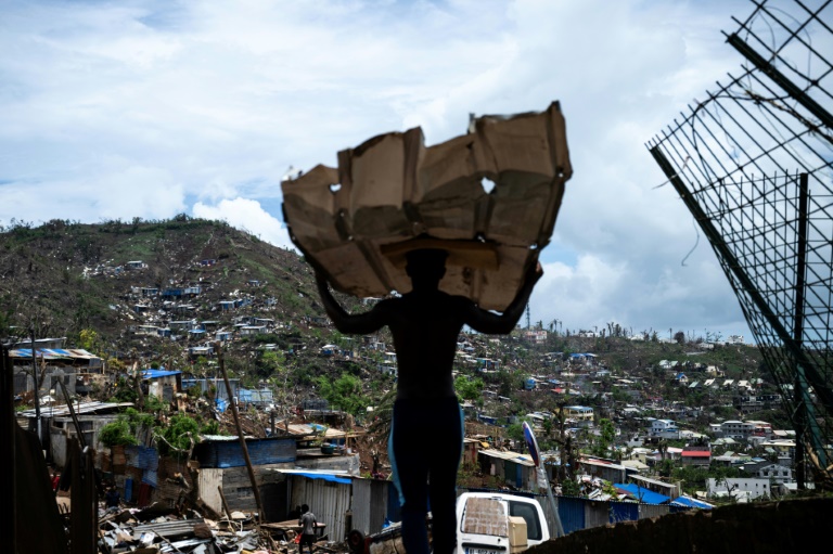 Un homme transporte de la taule pour reconstruire sa maison après le passage du cyclone Chido à Mamoudzou, à Mayotte, le 2 janvier 2025
