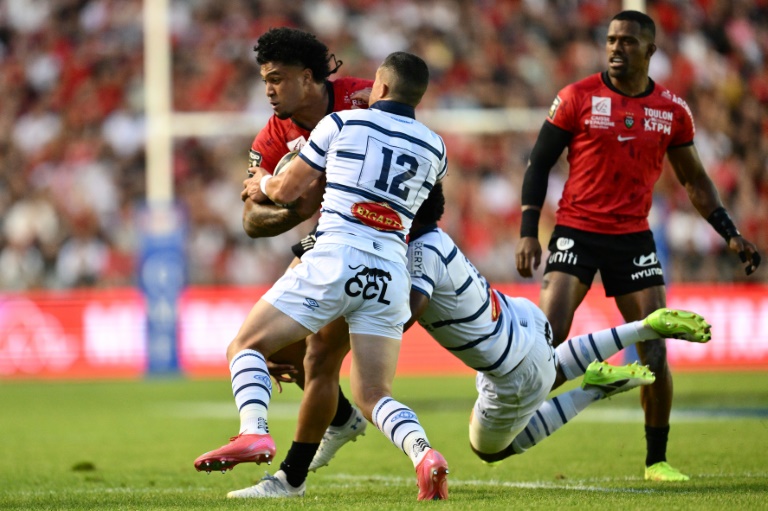 Le Toulonnais Leicester Fainga'anuku (g) est plaqué par le Castrais Adrien Seguret (C) durant le barrage de Top 14 remporté par les Varois (52-23), le 14 juin 2025 au stade Mayol