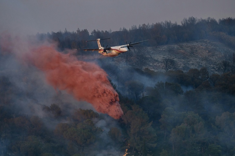 Un avion Dash largue du retardant sur les flammes d'un incendie près de Bizanet, le 29 juin 2025