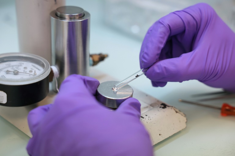Un technicien presse des échantillons de graphite dans une cathode en aluminium afin d’éviter toute contamination avant le processus de mesure, au laboratoire LMC14 (Laboratoire de Mesure du Carbone 14) du Commissariat à l’Énergie Atomique et aux Énergies Alternatives (CEA), à Saclay, le 22 mai 2025.