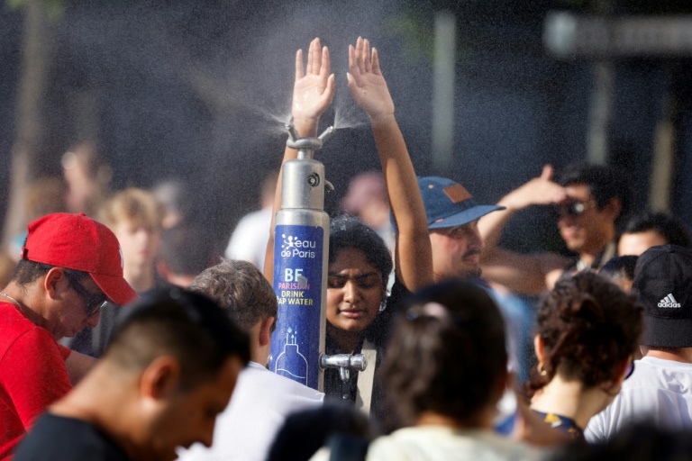 Des personnes se rafraîchissent à une fontaine à Paris, le 30 juin 2025