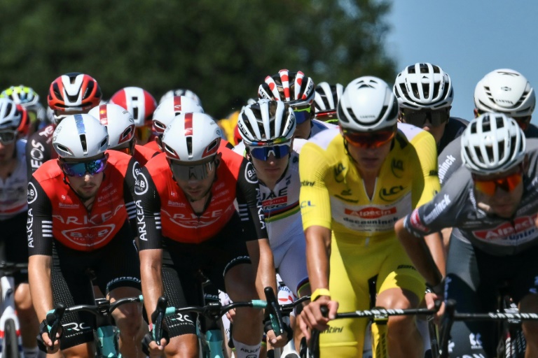 Kévin Vauquelin, en rouge au centre, parmi les leaders du peloton du Tour de France, dont le champion du monde Tadej Pogacar et le maillot jaune Mathieu van der Poel, sur la route de Mûr-de-Bretagne (7e étape), le 11 juillet 2025