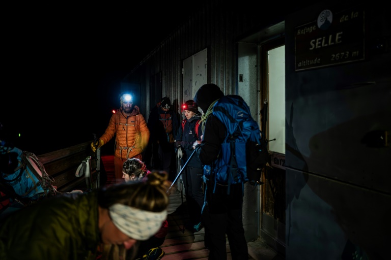 Des randonneurs partent du refuge à l'aube pour gravir le glacier de la Selle dans le massif des Ecrins, à Saint-Christophe-en-Oisans, en Isère, le 9 juillet 2025