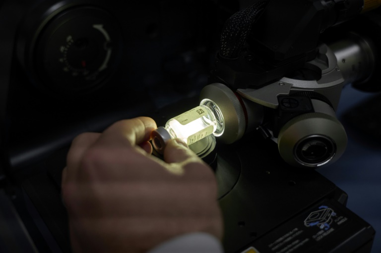 Un technicien de laboratoire utilise un microscope pour examiner un vaccin contrefait dans le laboratoire central d'analyse des contrefaçons de Sanofi, le 18 mars 2025 à Tours