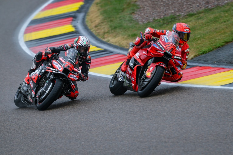 Le pilote espagnol Marc Marquez (à droite) double l'Italien Marco Bezzecchi (Aprilia) dans le dernier tour de la course sprint du Grand Prix d'Allemagne MotoGP sur le circuit du Sachsenring le 12 juillet 2025.