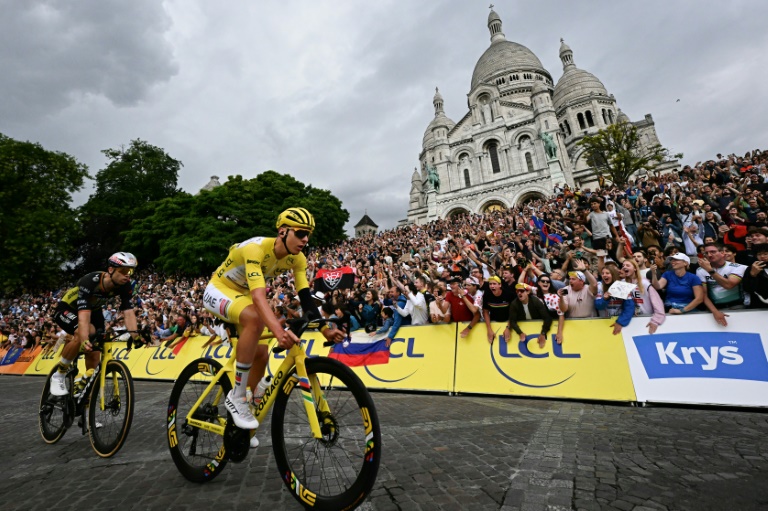 Tadej Pogacar (D) et Wout Van Aert devant la basilique du Sacré-Coeur lors de la dernière étape du Tour de France, à Paris, le 27 juillet 2025