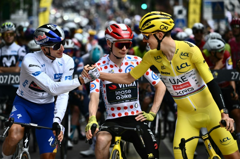 L'Allemand Florian Lipowitz (G) avec Jonas Vingegaard (C) et Tadej Pogacar au départ de la dernière étape du Tour de France, à Mantes-la-Ville, le 27 juillet 2025