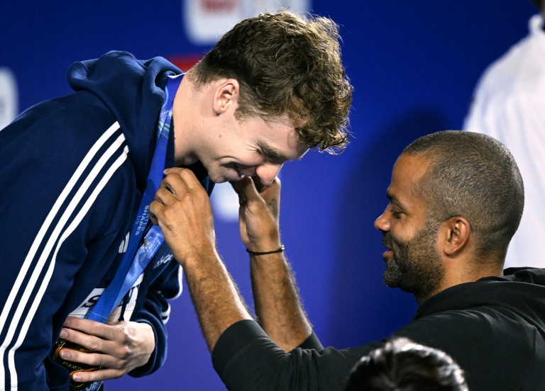 L'ancien basketteur français Tony Parker remet la médaille d'or à Léon Marchand après sa victoire au 200 m quatre nages aux championnats du monde de natation à Singapour le 31 juillet 2025