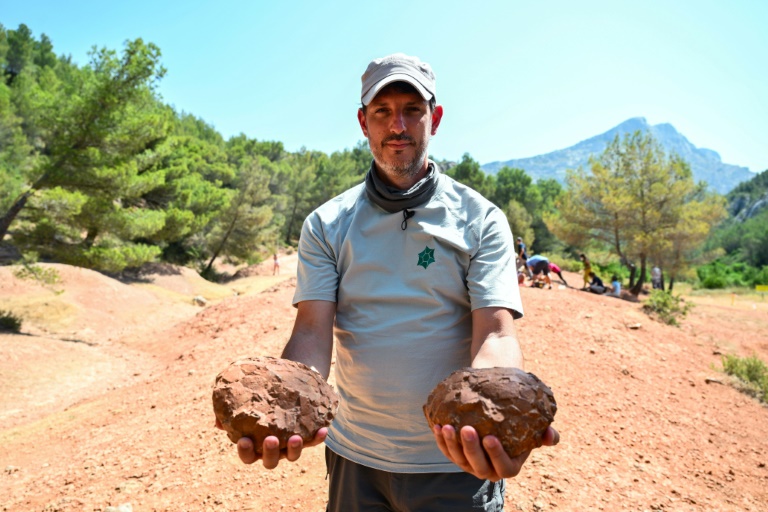 Thierry Tortosa, paléontologue et conservateur de la Réserve Naturelle Nationale de Sainte-Victoire, montre des oeufs de dinosaures trouvés sur le site, le 25 juin 2025 près d'Aix-en-Provence, dans les Bouches-du-Rhône