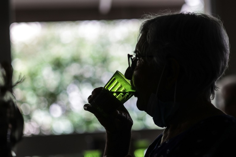 Une femme boit un verre d'eau, dans une résidence sénior de Bordeaux, le 16 juin 2022 lors d'une vague de chaleur