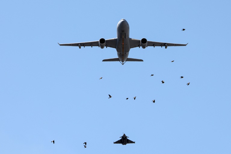 Un avion de chasse Rafale et un avion ravitailleur Boeing KC-135 de l'Armée de l'air française survolent l'Arc de Triomphe, à Paris, le 9 juillet 2025, lors d'une répétition du défilé annuel du 14 juillet