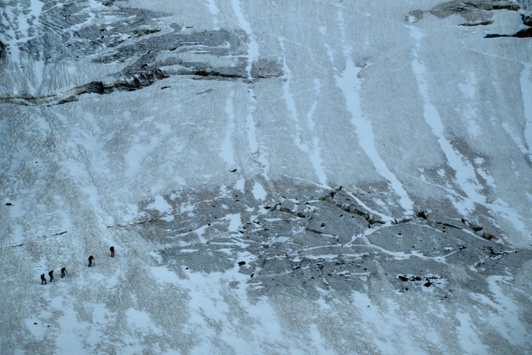 Des alpinistes marchent le long des crevasses du glacier de la Selle dans le massif des Écrins, tôt le matin, le 9 juillet 2025 à Saint-Christophe-en-Oisans, en Isère