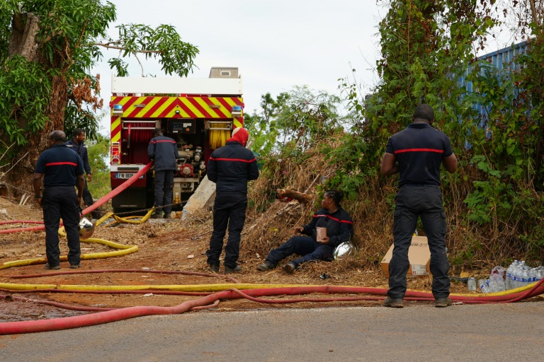 Des pompiers tentent d'éteindre un feu provenant de cultures sur brûlis, au village d'Inroni Bé, Mayotte, le 12 août 2025