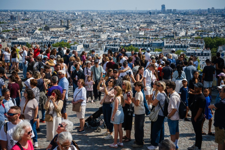 Des touristes au pied de la basilique du Sacré-Coeur à Montmartre, le 5 août 2025 à Paris