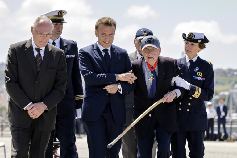 Le président de la République Emmanuel Macron (2e à gauche) avec le vétéran Paul Leterrier (2e à droite) à Cherbourg, dans la Manche, le 7 juin 2024 pour les cérémonies du 80e anniversaire du Débarquement en Normandie