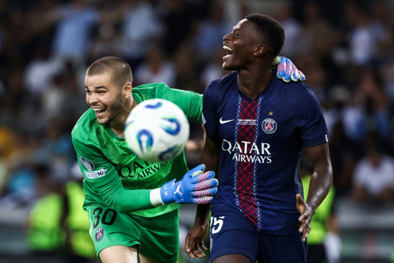 Le défenseur portugais du Paris SG Nuno Mendes (droite) est félicité par le gardien Lucas Chevalier après avoir inscrit le tir au but de la victoire en Supercoupe d'Europe contre Tottenham le 13 août 2025 à Udine (Italie)
