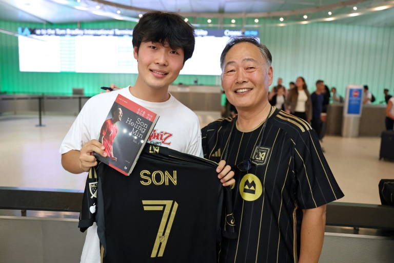 Jun Kwon (g) et son père Hojin Kwon, supporters de la star coréenne Son Heung-min, qui vient de s'engager avec le Los Angeles FC, le 5 août 2025 à l'aéroport de Los Angeles