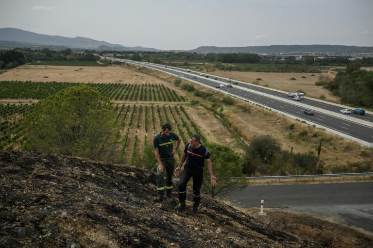 Stéphane Paoli (g), technicien de l'ONF, et Jean-Paul Baylac, chef du service des incendies de forêt du Service d'incendie et de secours de l'Aude, inspectent une zone touchée par un récent incendie de forêt, à Luc-sur-Orbieu, près de Narbonne, le 19 août 2025