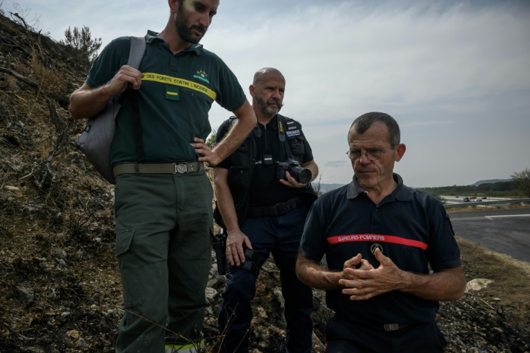 (g-d) Stéphane Paoli, technicien de l'ONF, le gendarmer Emmanuel Guinard et Jean-Paul Baylac, chef du service des incendies de forêt du Service d'incendie et de secours de l'Aude, inspectent une zone touchée par un récent incendie de forêt, à Luc-sur-Orbieu, près de Narbonne, le 19 août 2025
