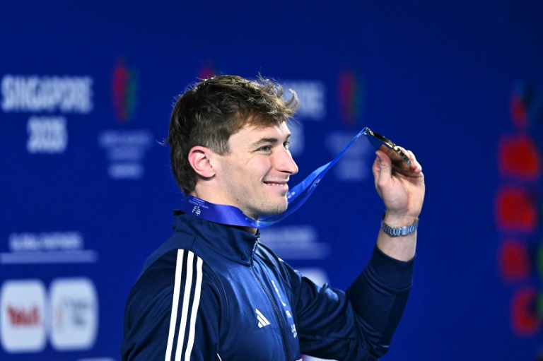 Le Français Maxime Grousset sur le podium avec sa médaille d'or après sa victoire sur le 100 m papillon aux championnats du monde de natation à Singapour le 2 août 2025