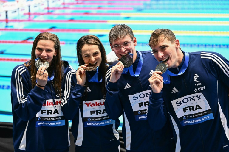Marie Wattel, Beryl Gastaldello, Yann Le Goff et Maxime Grousset (de gauche) sur le podium du 4x100 m mixte dont ils ont pris la troisième place, derrière les Etats-Unis et la Russie le 2 août 2025 à Singapour