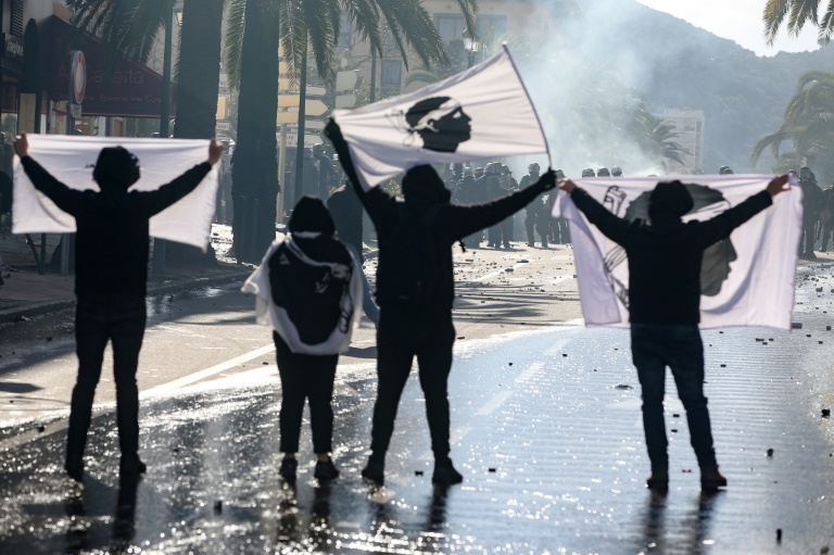 Des manifestants brandissent des drapeaux de la Corse face aux CRS, le 3 avril 2022 à Ajaccio, après un rassemblement en hommage au militant indépendantiste Yvan Colonna, mortellement agressé en prison