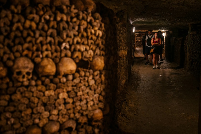 Des touristes visitent les Catacombes de Paris, le 12 août 2025