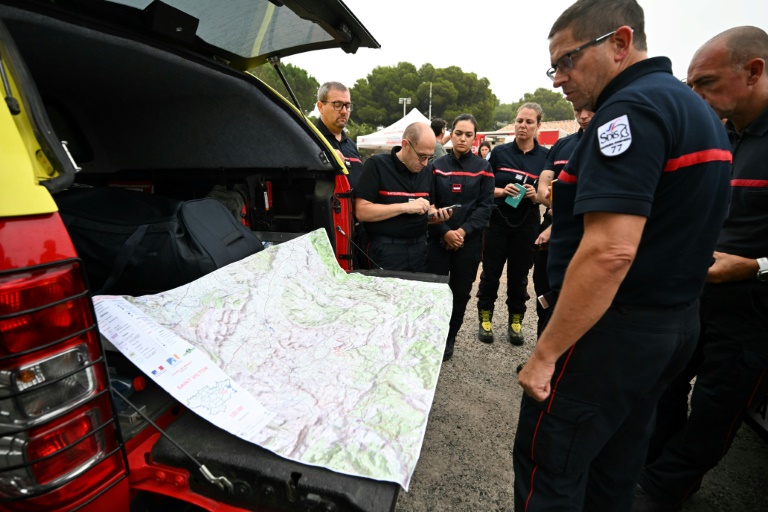 Des pompiers consultent une carte à n Saint-Laurent-de-la-Cabrerisse, dans l'Aude, où un incendie a parcouru quelque 16.000 hectares dans le massif des Corbières, le 8 août 2025