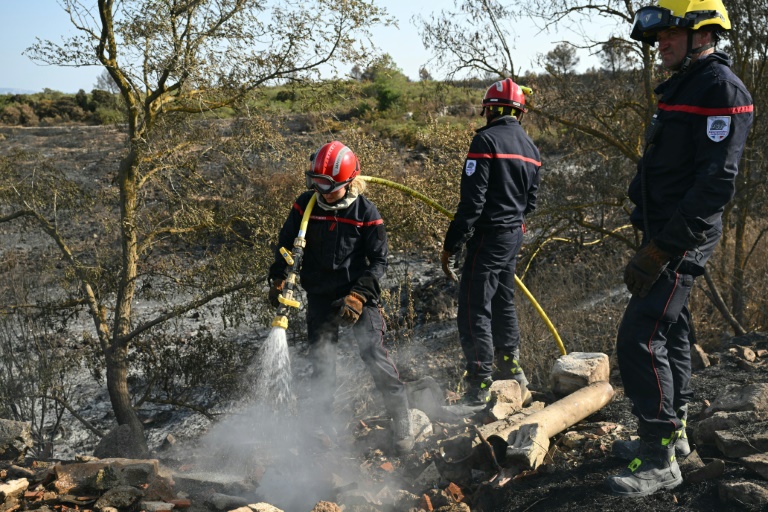 Des pompiers éteignent des cendres chaudes à côté d'Albas, dans le massif des Corbières, le 9 août 2025