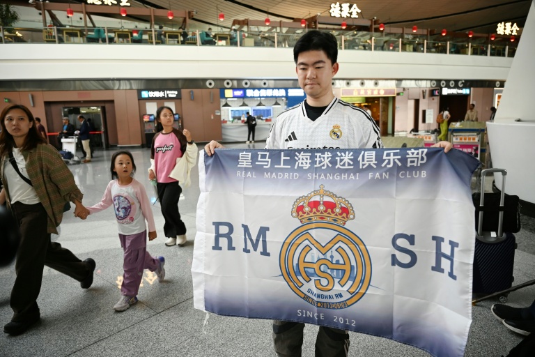 Alex Lee, un supporter chinois du Real Madrid, pose à l'aéroport de Pékin avant d'aller assister au match de Ligue des champions entre le Kaïrat Almaty et le club espagnol le 29 septembre 2025