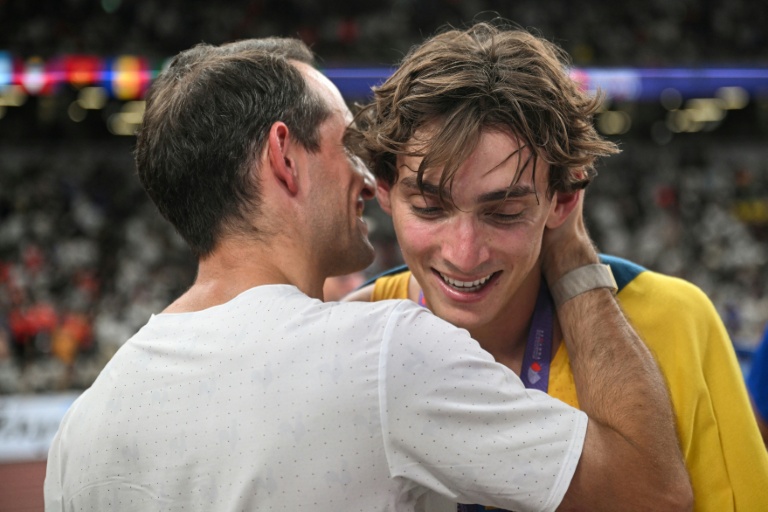 Le champion du monde suédois Armand Duplantis (à droite) célèbre son nouveau record du monde lors de la finale du saut à la perche masculin avec l'athlète français Renaud Lavillenie, lors des Championnats du monde d'athlétisme à Tokyo, le 15 septembre 2025