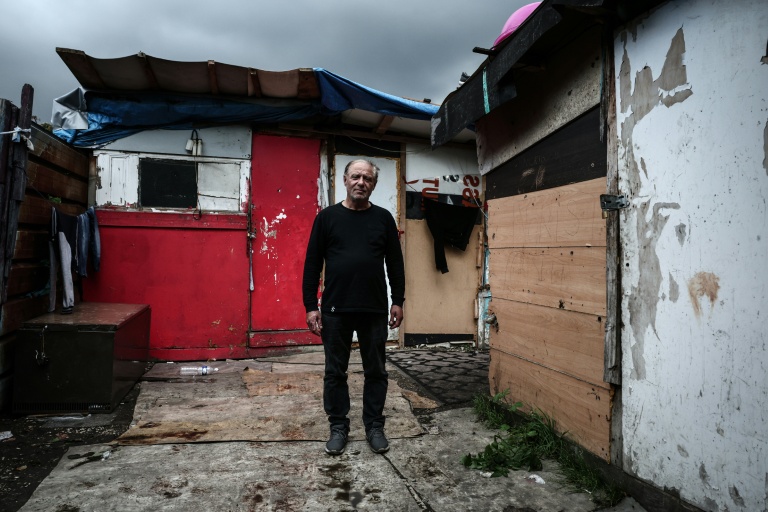 Vasile, un habitant du bidonville, pose pour une photo le 26 septembre 2025, au milieu des cabanes de Stains, en banlieue parisienne