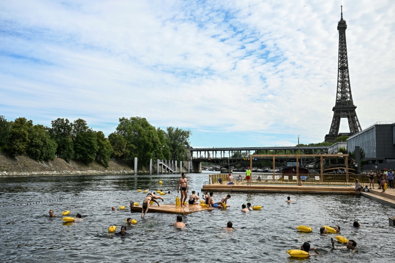 Des baigneurs nagent dans la Seine sur un site aménagé sur le bras de Seine de Grenelle, près de la tour Eiffel (en arrière-plan), à Paris, le 5 juillet 2025
