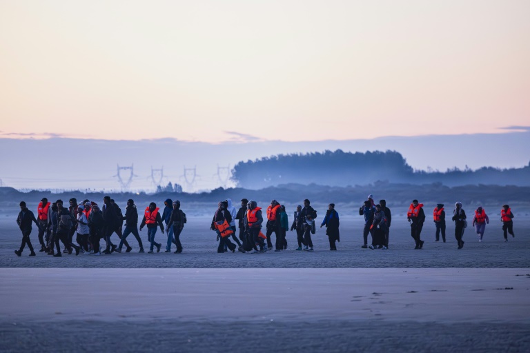Des migrants arrivent sur la plage de Gravelines pour prendre un bateau de passeurs et tenter de traverser la Manche, le 27 septembre 2025 dans le Nord