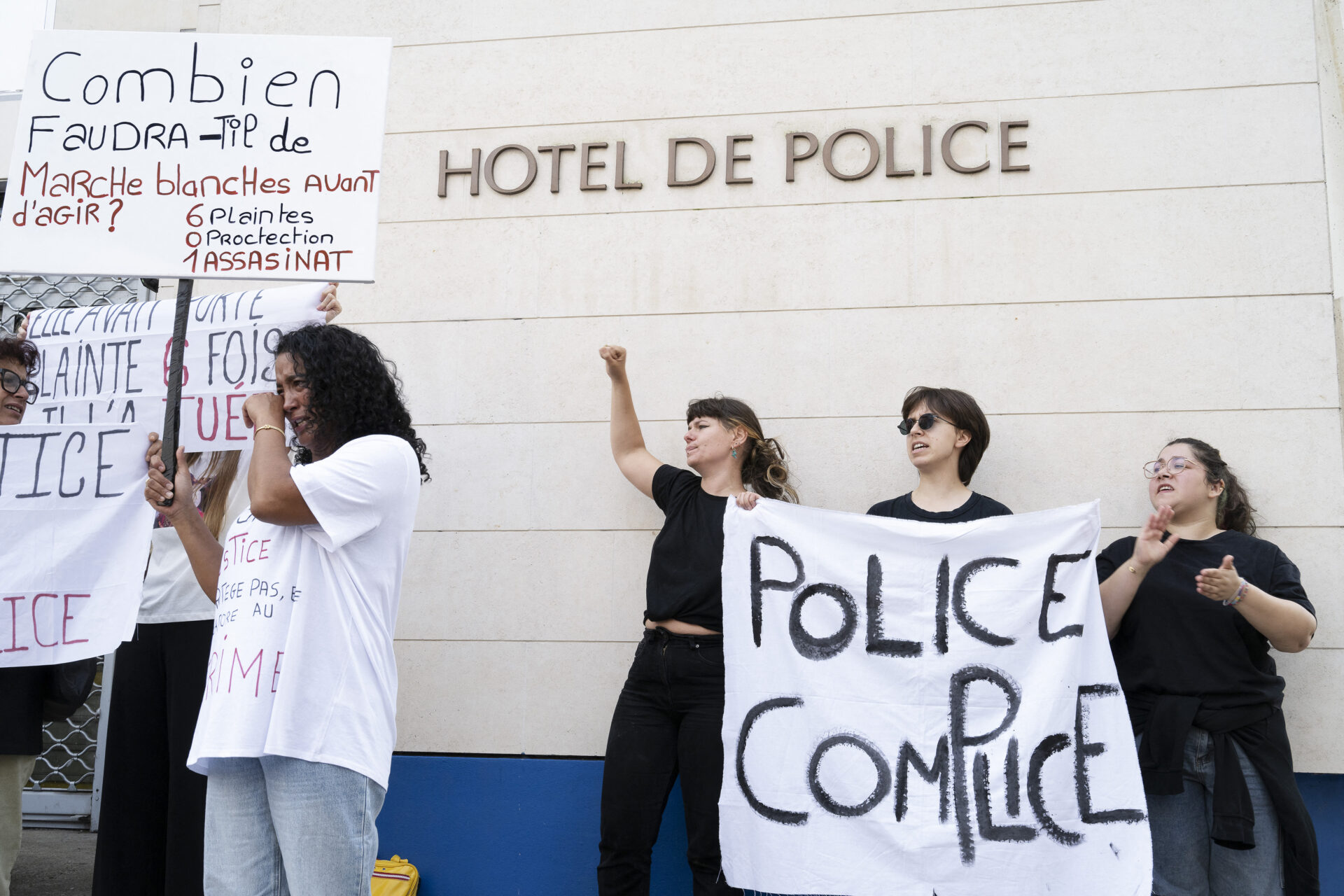 France, Poitiers, 2025-0920. Au moins 1200 personnes participent a la marche blanche a la memoire d Ines Mecellem 25 ans, tuee par son ex-compagnon a coups de couteau devant chez elle le 8 septembre. Violentee et menacee de mort, Ines avait porte plainte a 6 reprises, elle beneficiait d un telephone grave danger qui ne l a pas protegee. La famille accuse aujourd hui la police de n avoir rien fait. Ici, devant l entree du commissariat, au-dessous de l inscription hotel de police, trois jeunes femmes tiennent un linge blanc sur lequel est inscrit : Police complice. Pres d elles, une autre femme essuie ses larmes.
