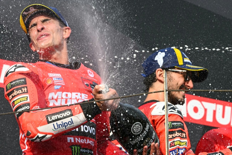 Marc Marquez (g) savoure son septième titre mondial MotoGP sur le podium du Grand Prix du Japon au côté de son coéquipier Francesco Bagnaia vainqueur de la course, le 28 septembre 2025 sur le circuit de Motegi.