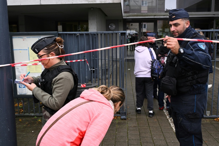 Des gendarmes et des policiers laissent entrer des parents d'élèves au lycée Robert Schuman à Benfeld, dans le nord-est de la France, le 24 septembre 2025