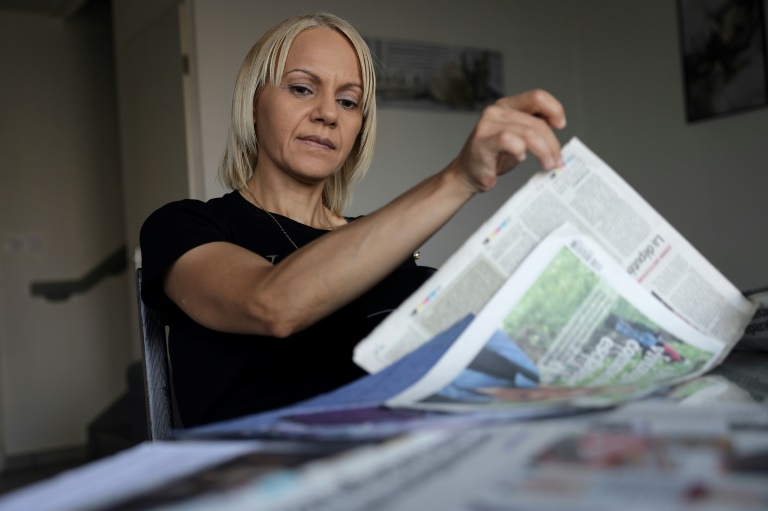 La Marocaine Yasmina Tellal, consulte des coupures de presse, dans le sud-ouest de la France, le 15 août 2025